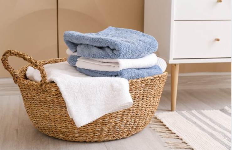 Cesta bucato on asciugamani piegati e puliti