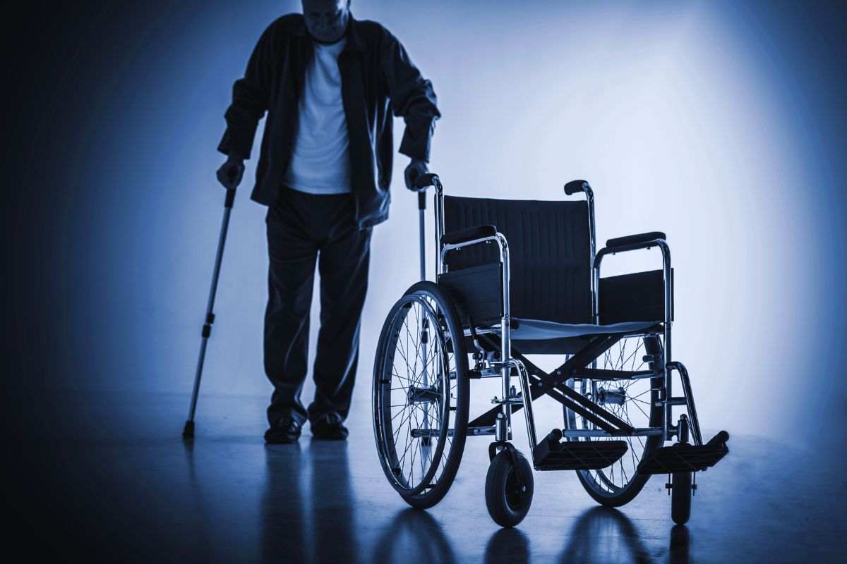 persona disabile in piedi e carrozzina