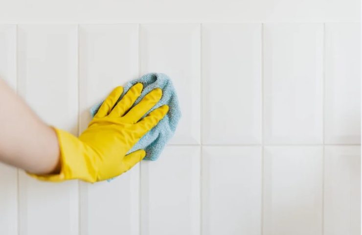 persona pulisce le fughe delle mattonelle