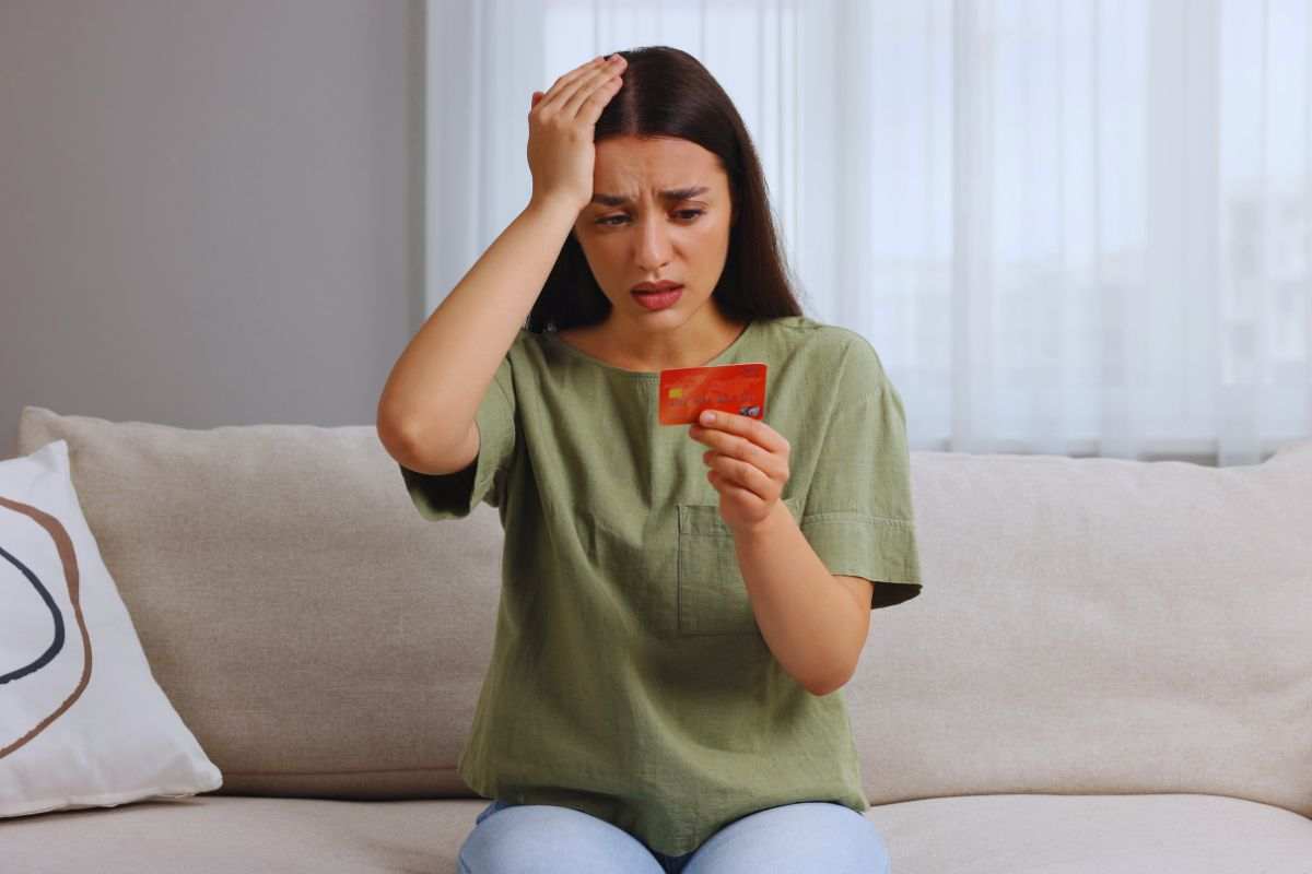 Donna preoccupata con carta di credito in mano