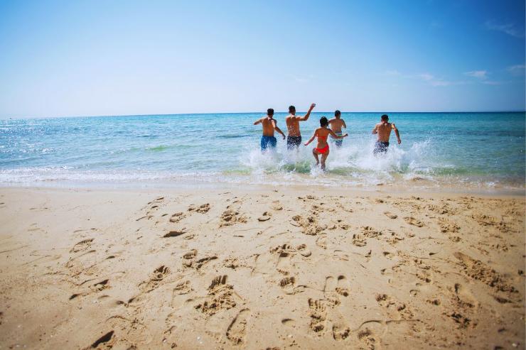 Gruppo di ragazzi che entra di corsa in acqua