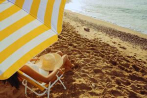 Donna in spiaggia sotto l'ombrellone