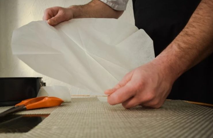 persona taglia a misura la carta da forno 