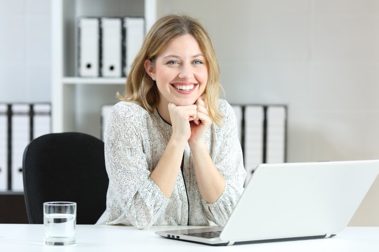 donna sorridente di fronte a pc