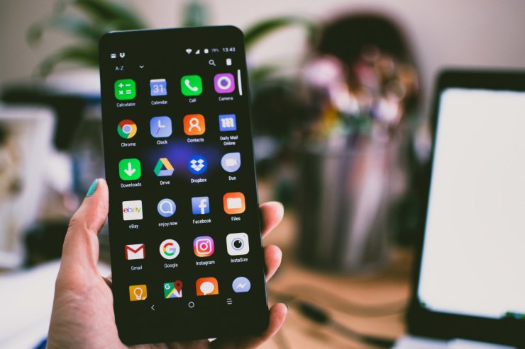 uomo con cellulare in mano e icone social